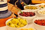 Erilaiset pavut, oliivit, pepperonit, mustekalan renkaat ja yrttimarinoidut valkosipulit kuuluvat Italialaiselle Illalliselle. Kuva: Anna-Reetta Nuorala
